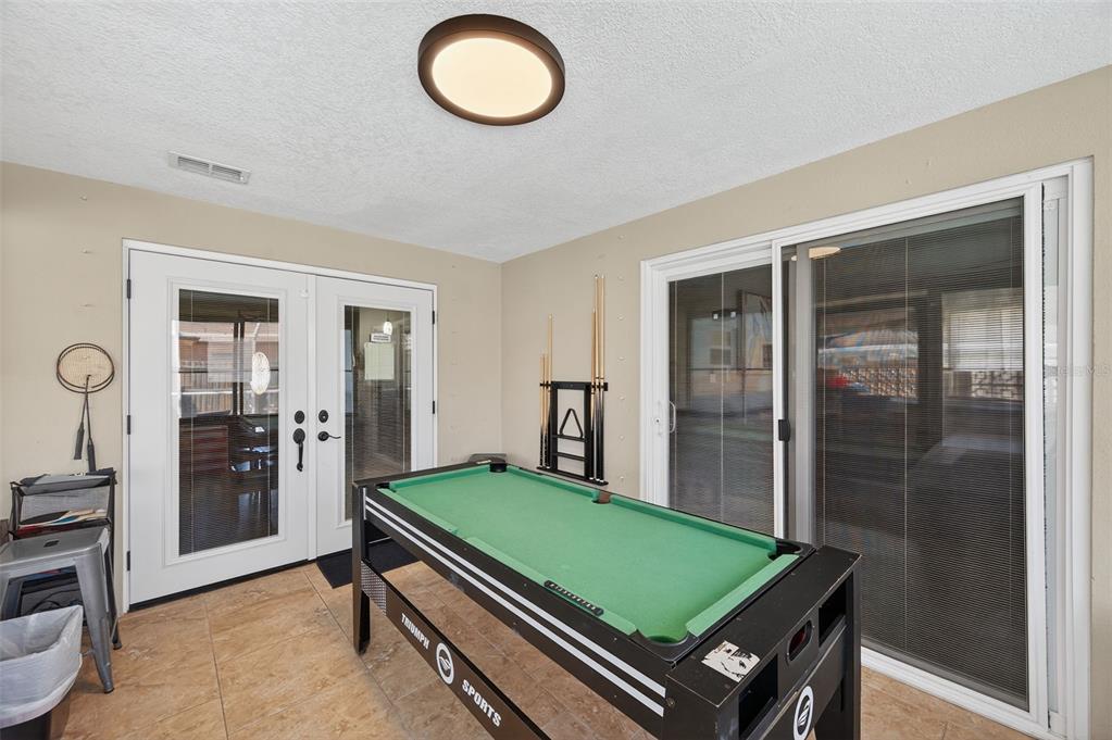 1576 Rosery Road Northeast Largo, FL 33756 - Photo 42 of 54 a room with pool table and glass door
