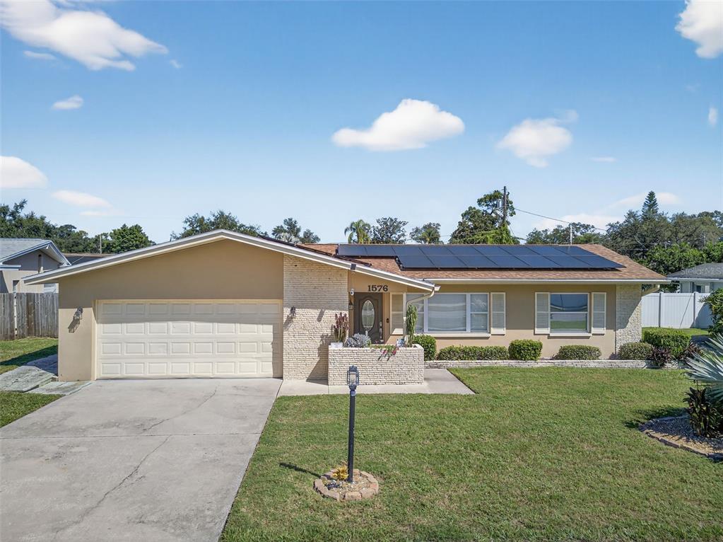 1576 Rosery Road Northeast Largo, FL 33756 - Photo 49 of 54 a front view of a house with a yard and a garage