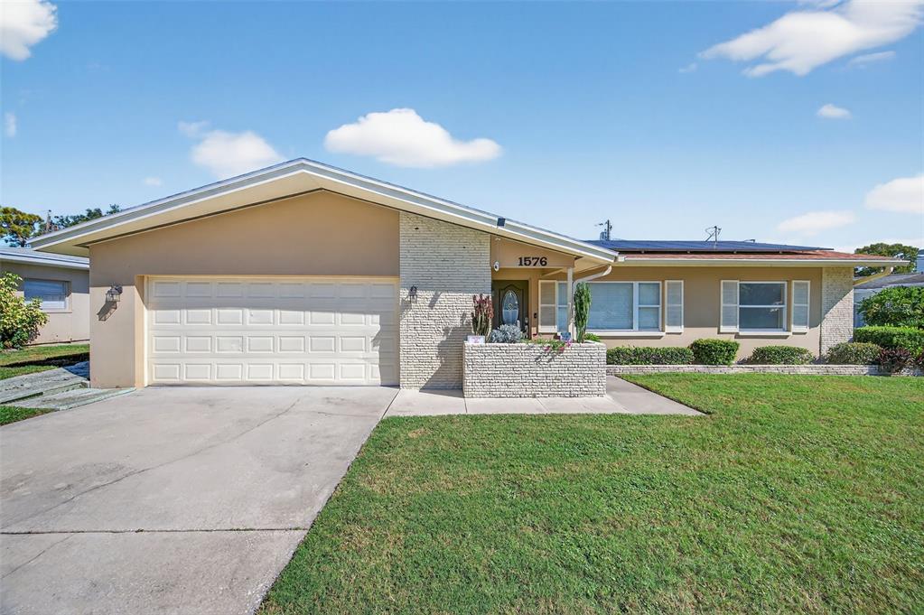 1576 Rosery Road Northeast Largo, FL 33756 - Photo 6 of 54 a front view of a house with a yard and garage