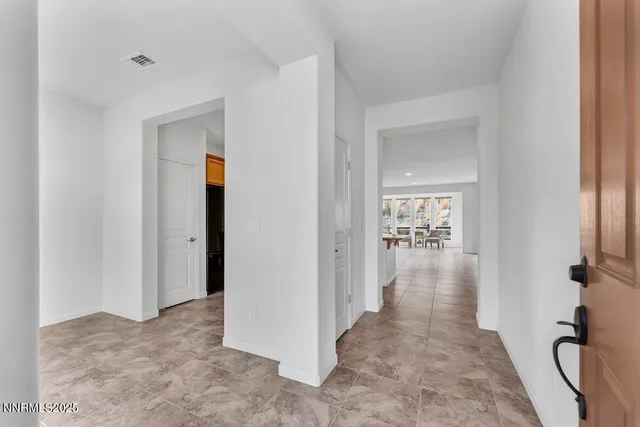 a view of a hallway with wooden floor and a bathroom