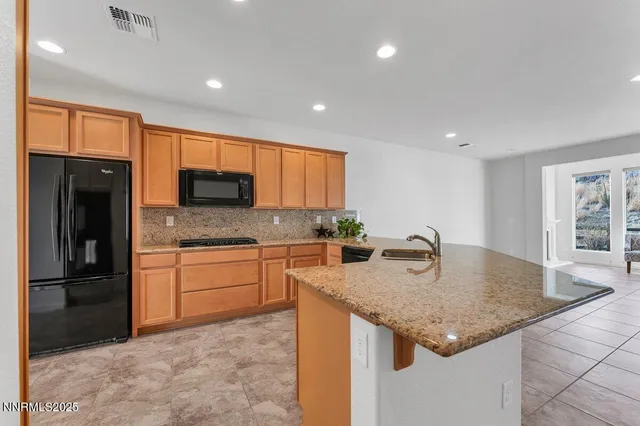 a kitchen with stainless steel appliances granite countertop a sink refrigerator and cabinets