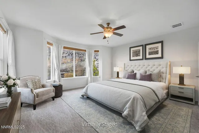 a spacious bedroom with a bed couch and a window