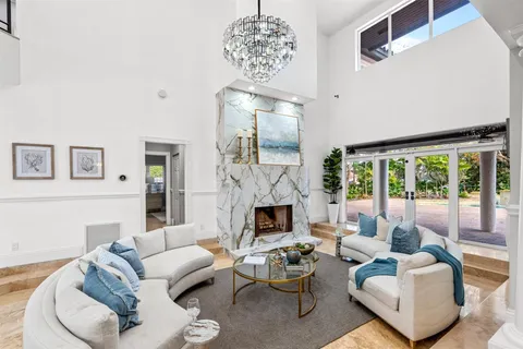 a living room with furniture a fireplace and a chandelier