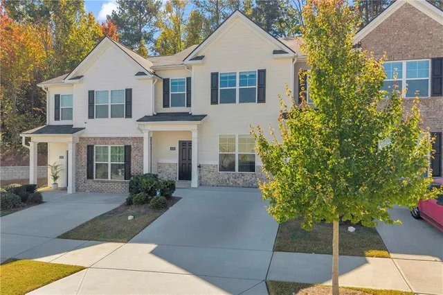 a front view of a house with a yard and trees