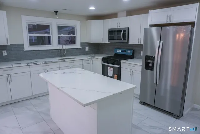 a kitchen with stainless steel appliances a refrigerator sink and microwave