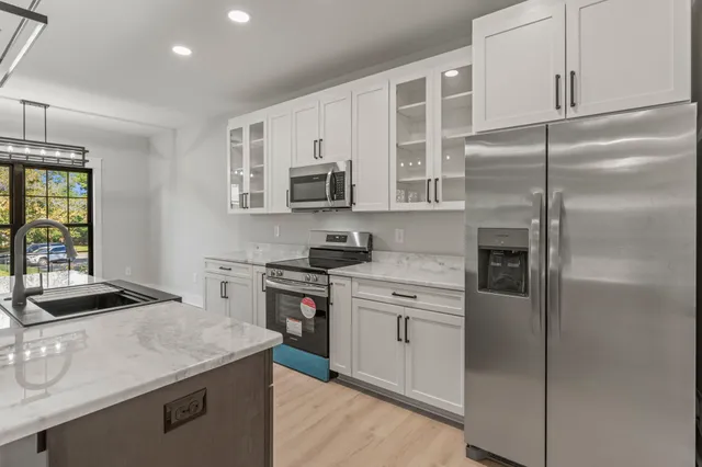 a kitchen with kitchen island granite countertop stainless steel appliances and refrigerator