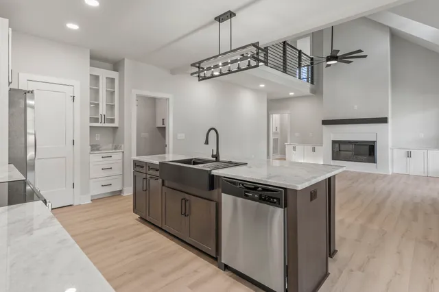 a kitchen with stainless steel appliances granite countertop a sink a stove and a refrigerator