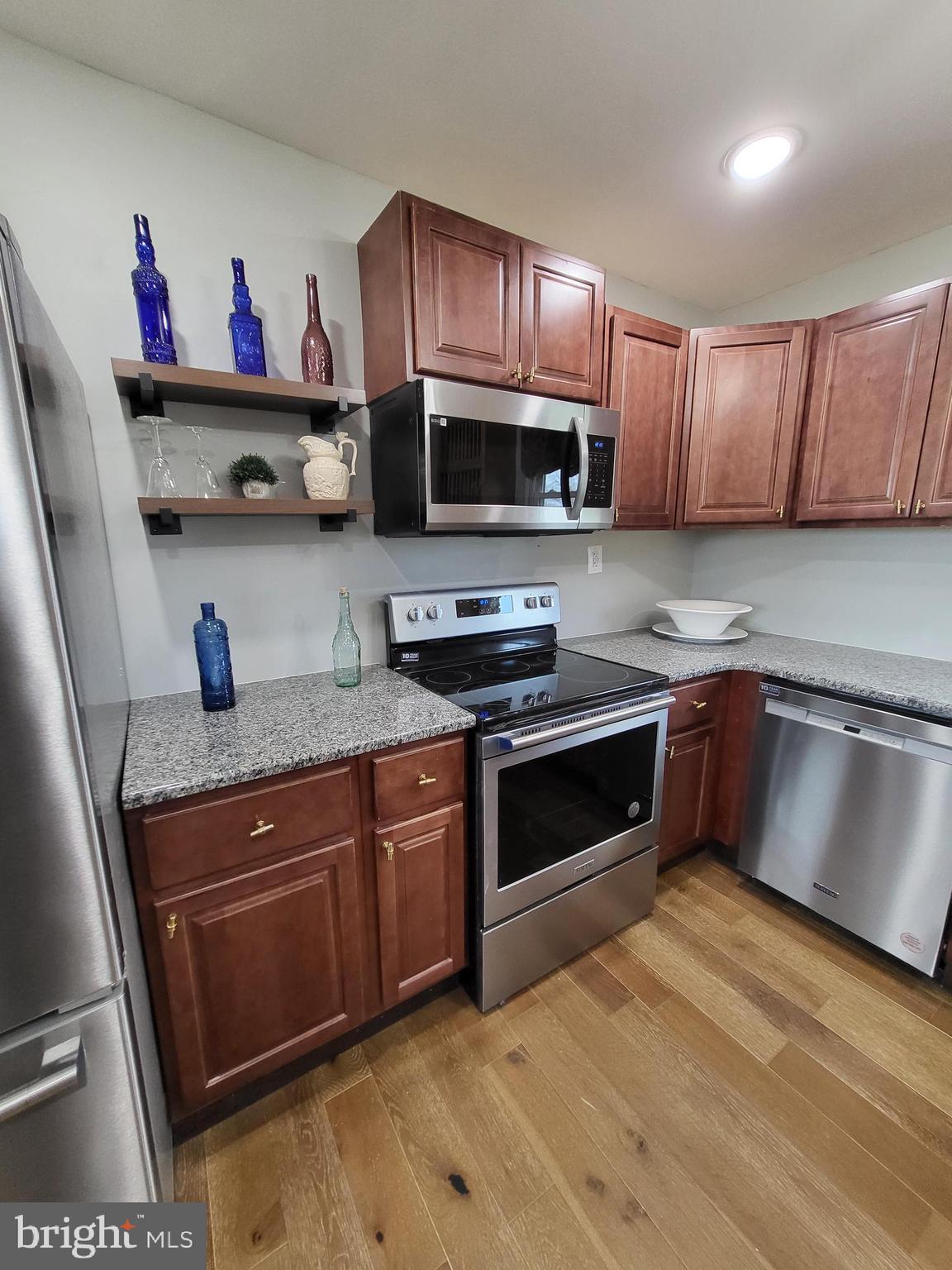 955 Kitts Hummock Road Dover, DE 19901 - Photo 5 of 16 a kitchen with stainless steel appliances granite countertop a stove a sink dishwasher and a microwave oven with cabinets