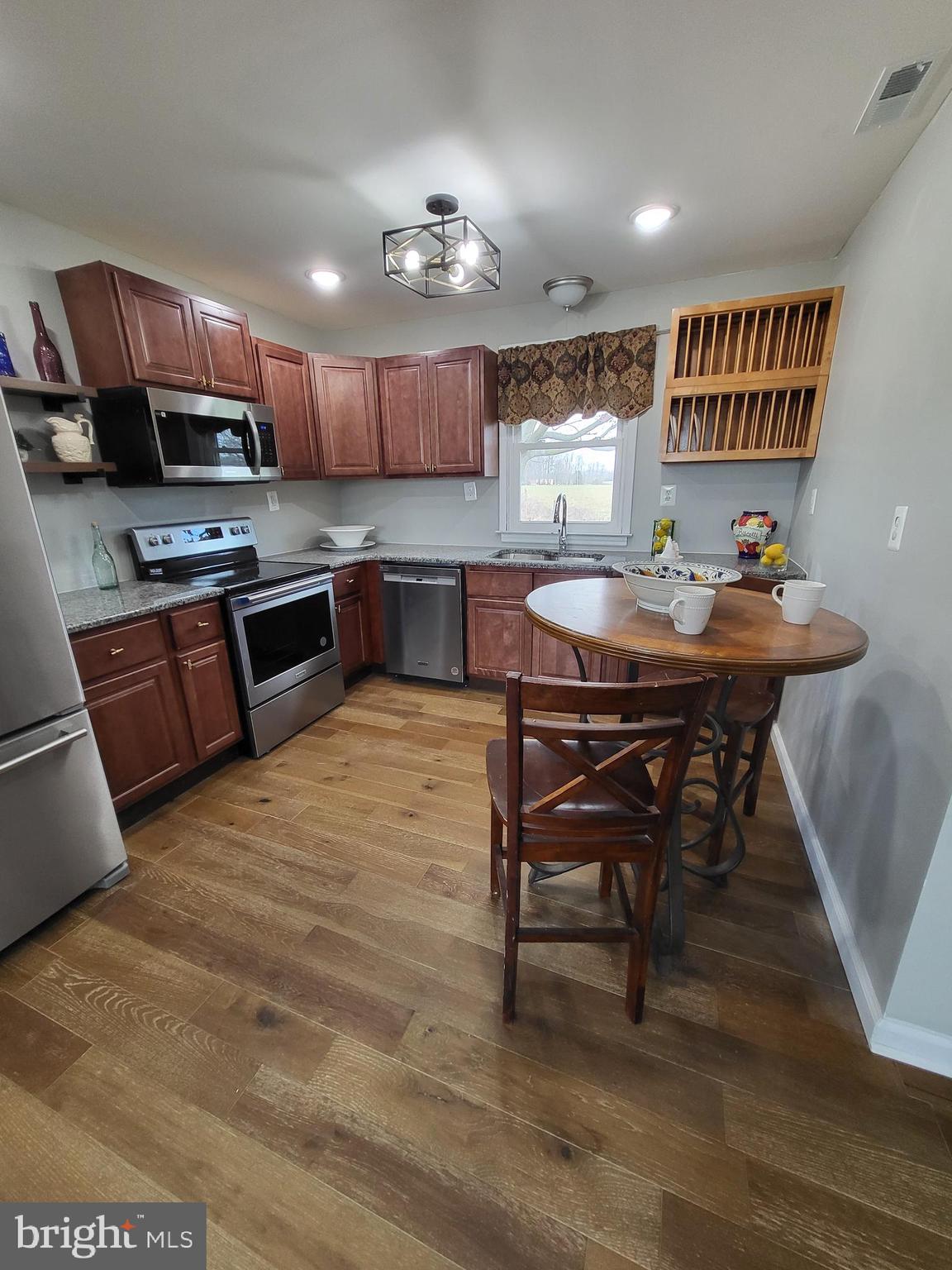 955 Kitts Hummock Road Dover, DE 19901 - Photo 6 of 16 a kitchen with stainless steel appliances kitchen island granite countertop a table chairs sink and cabinets