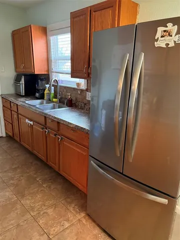 a kitchen with stainless steel appliances granite countertop a refrigerator a sink and a stove