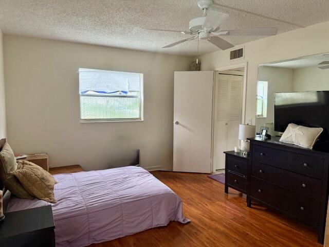 151 Tuscany Lane, Unit 151 Delray Beach, FL 33446 - Photo 2 of 4 a bedroom with a bed and wooden floor