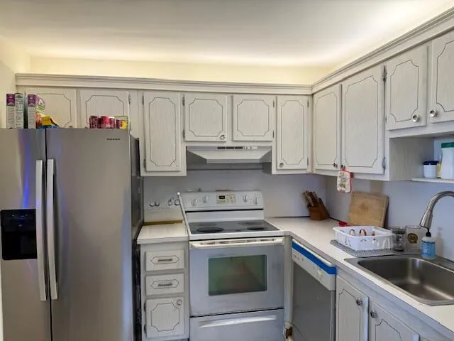 a kitchen with stainless steel appliances granite countertop a refrigerator sink and cabinets