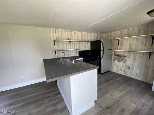 a kitchen with kitchen island a sink appliances and cabinets