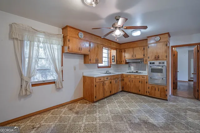 a large kitchen with stainless steel appliances granite countertop a stove refrigerator and cabinets