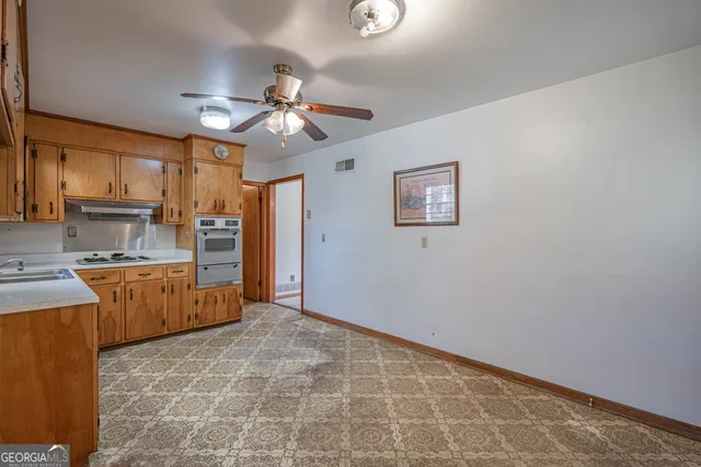 a kitchen with granite countertop a refrigerator and a stove top oven