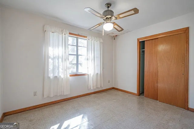 an empty room with a chandelier fan and a ceiling fan