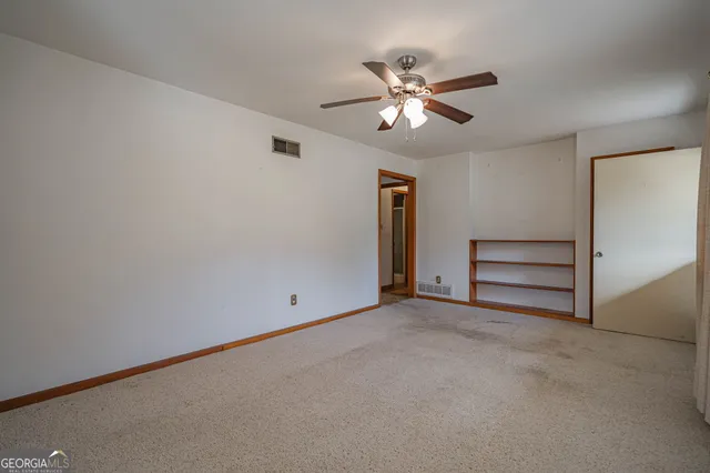 a view of room with chandelier fan and windows