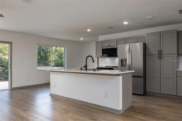 a kitchen with white cabinets and a refrigerator