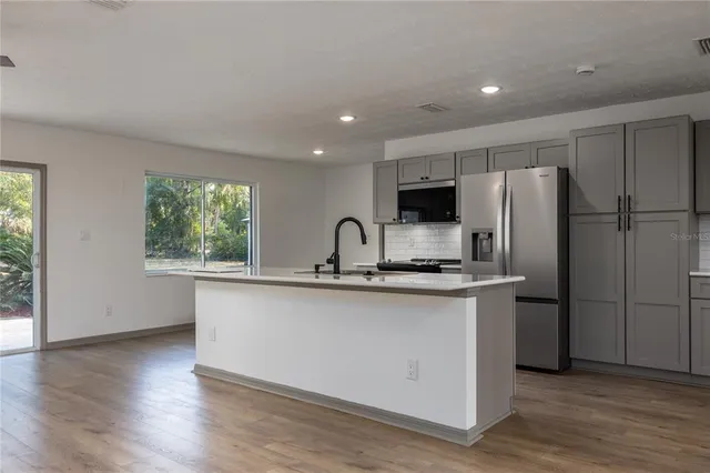 a kitchen with white cabinets and a refrigerator