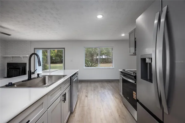 a kitchen with stainless steel appliances a sink and a refrigerator
