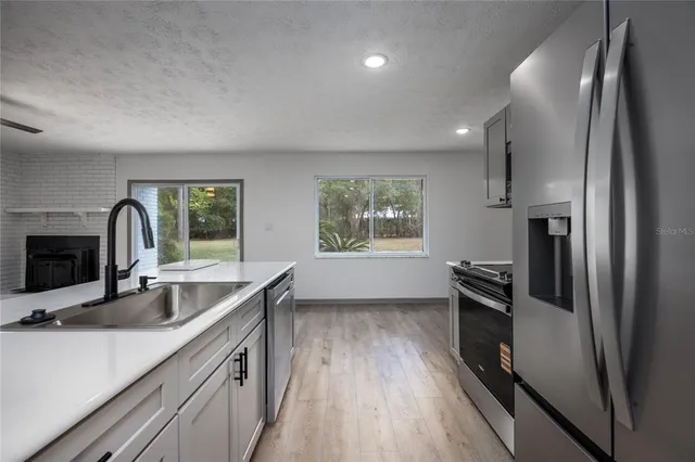 a kitchen with stainless steel appliances a sink and a refrigerator