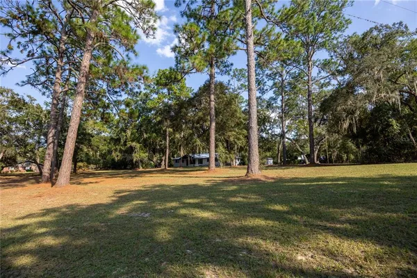 a front view of a house with a garden and trees