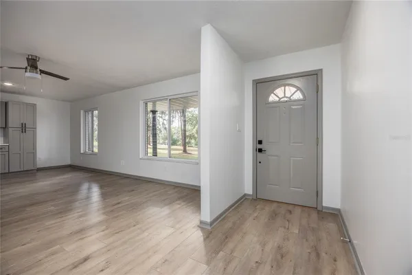 a living room with couches a large window and a potted plant
