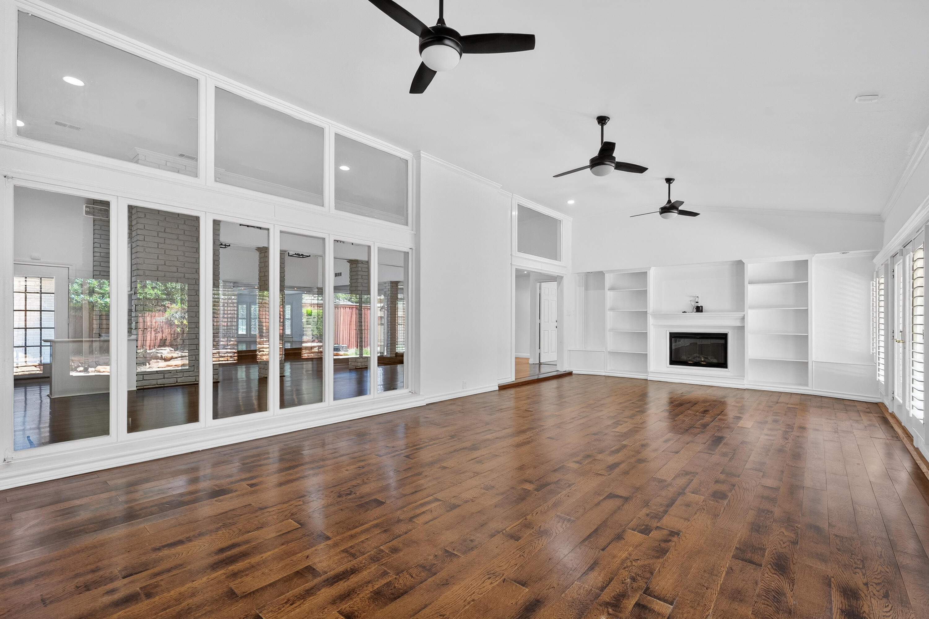 4616 9th Street Lubbock, TX 79416 - Photo 14 of 53 a view of an empty room with a window and wooden floor