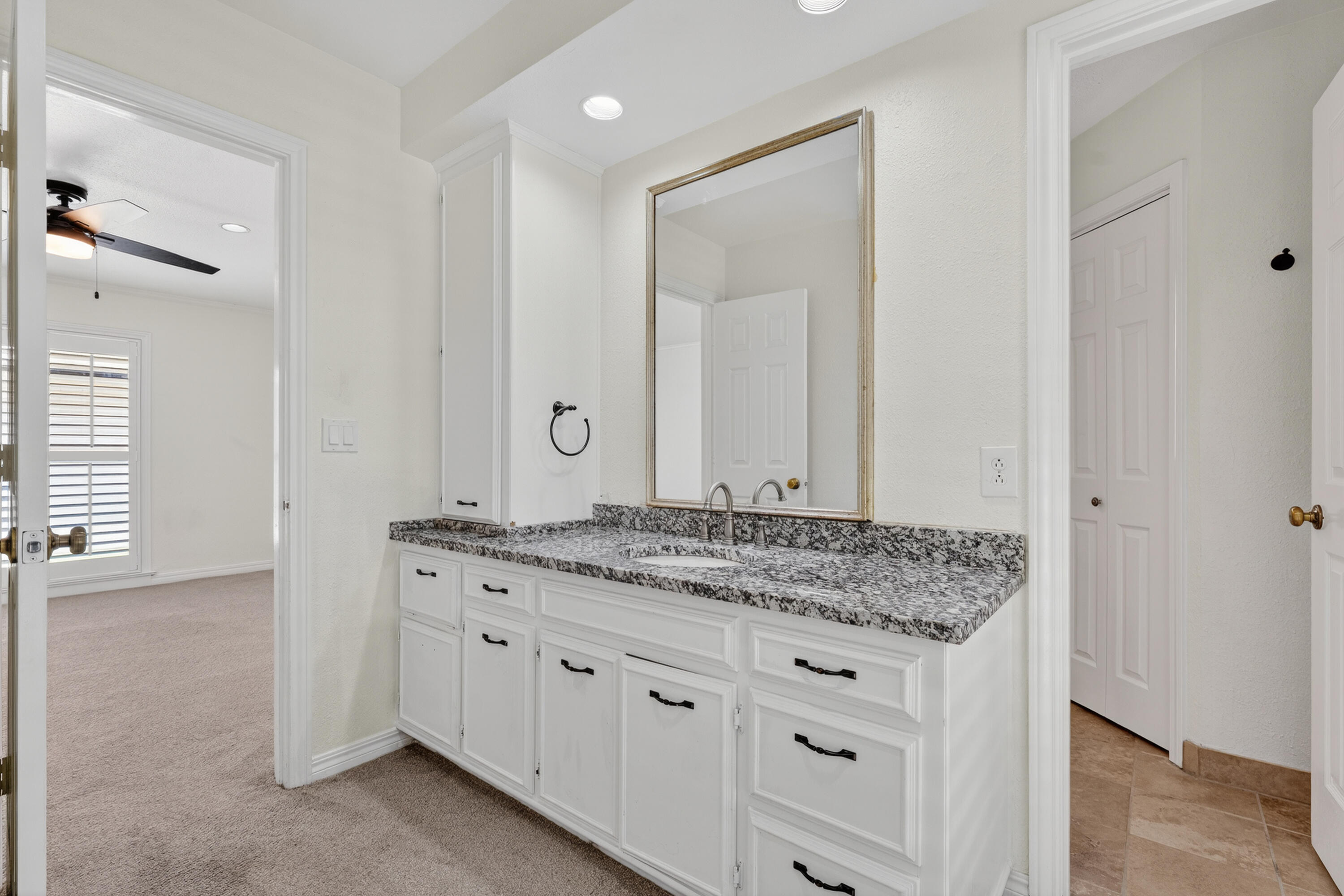 4616 9th Street Lubbock, TX 79416 - Photo 41 of 53 a bathroom with a granite countertop sink and a mirror