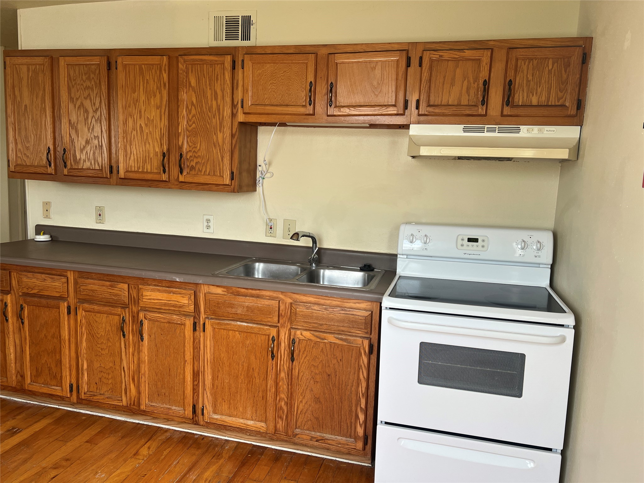 1201 Gillette Street, Unit 4 Houston, TX 77019 - Photo 4 of 12 a kitchen with stainless steel appliances granite countertop a sink and cabinets with wooden floor
