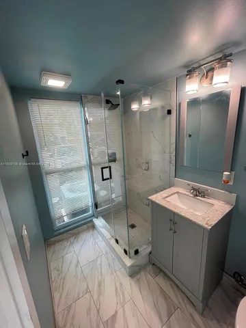 a bathroom with a sink mirror and shower