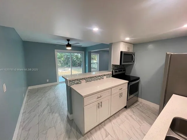 a kitchen with a stove a sink and a refrigerator