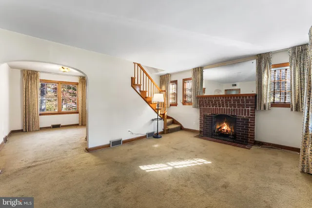 an empty room with windows fireplace and windows