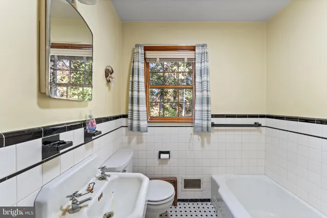 a bathroom with a tub a sink and a window