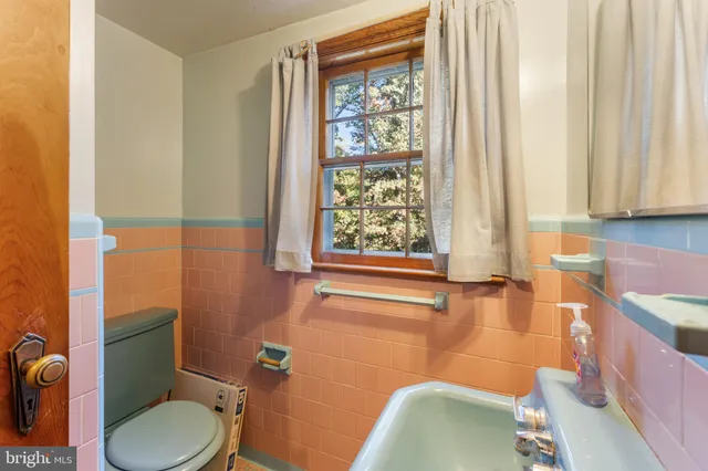 a bathroom with a toilet and a shower curtain