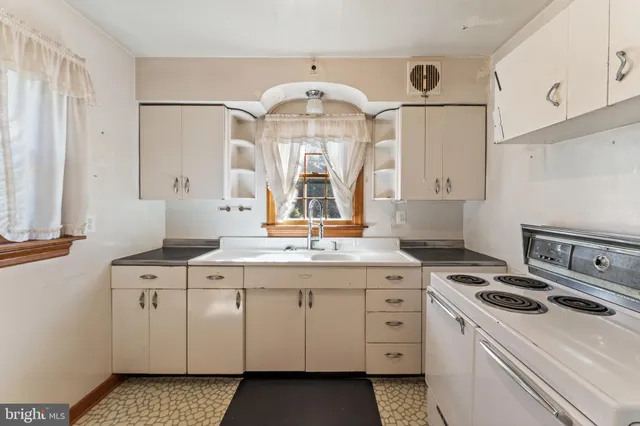 a kitchen with a stove a sink and a refrigerator