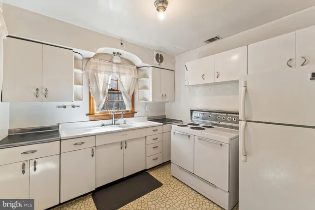 a kitchen with white cabinets and white appliances