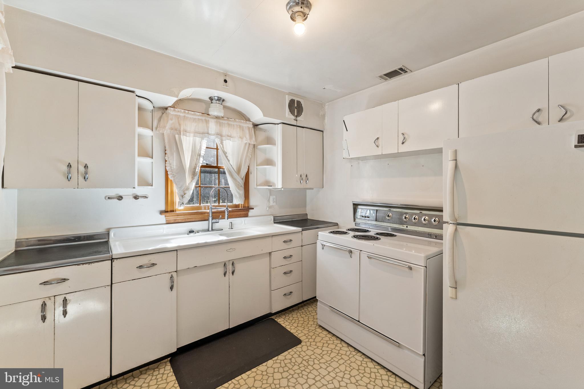 12606 Sub-Station Road Waldorf, MD 20601 - Photo 8 of 44 a kitchen with white cabinets and white appliances