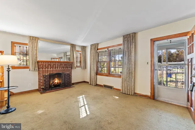 a view of an empty room with fireplace and a window