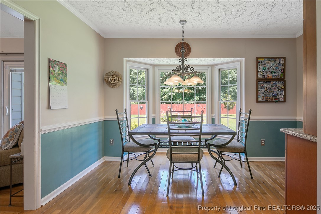 6528 Foxberry Road Fayetteville, NC 28314 - Photo 15 of 50 a view of a dining room with furniture a chandelier and wooden floor