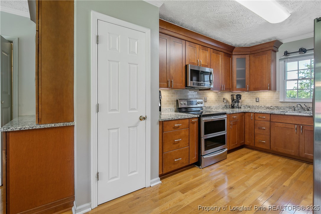 6528 Foxberry Road Fayetteville, NC 28314 - Photo 20 of 50 a kitchen with stainless steel appliances granite countertop a stove a sink and a refrigerator