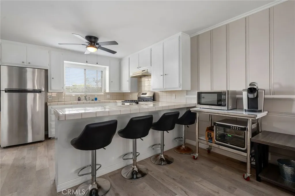 24 Surfside Avenue Surfside, CA 90743 - Photo 7 of 22 a kitchen with kitchen island granite countertop a counter space a sink appliances and cabinets