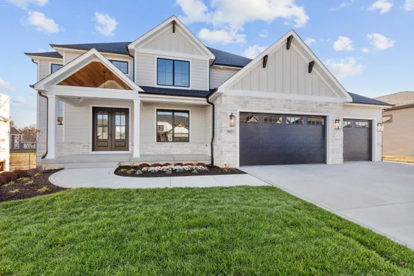 a front view of a house with yard and garage