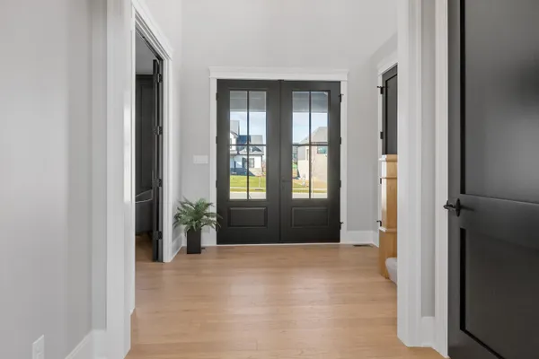 a view of a hallway with wooden floor kitchen and living room