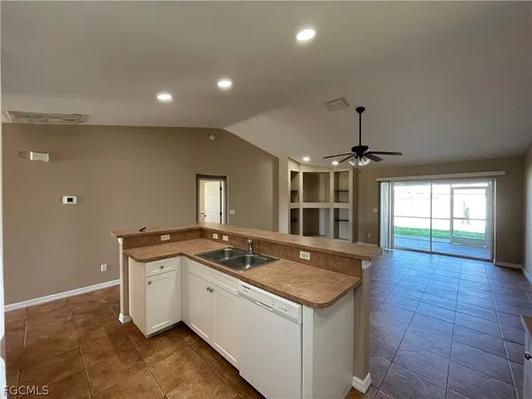 a view of an empty room with a chandelier fan
