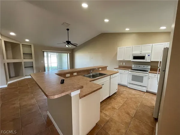 a kitchen with stainless steel appliances granite countertop a sink a stove and a center island