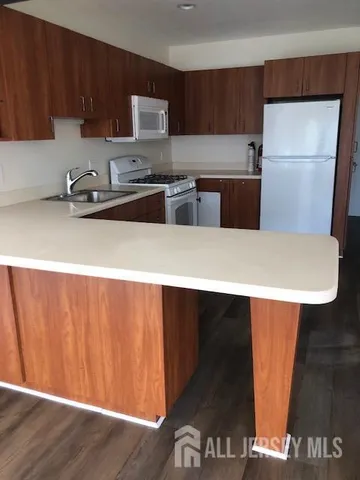 a kitchen with a sink a refrigerator and cabinets