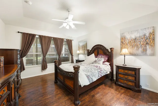 a bedroom with a bed lamp and a large window with wooden floor