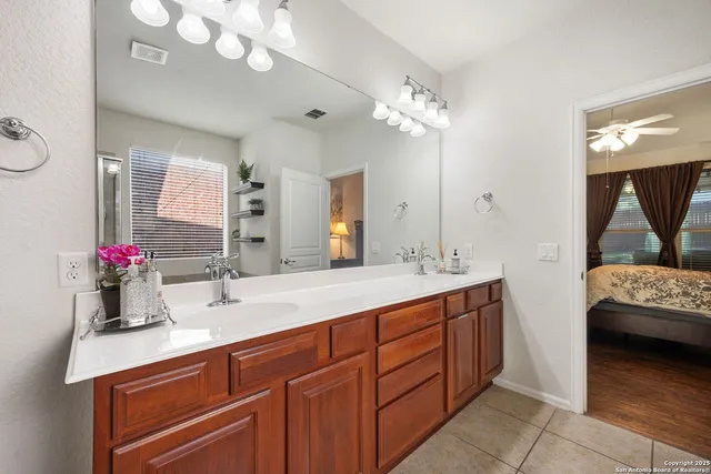 a en suite bathroom with double vanity and a mirror