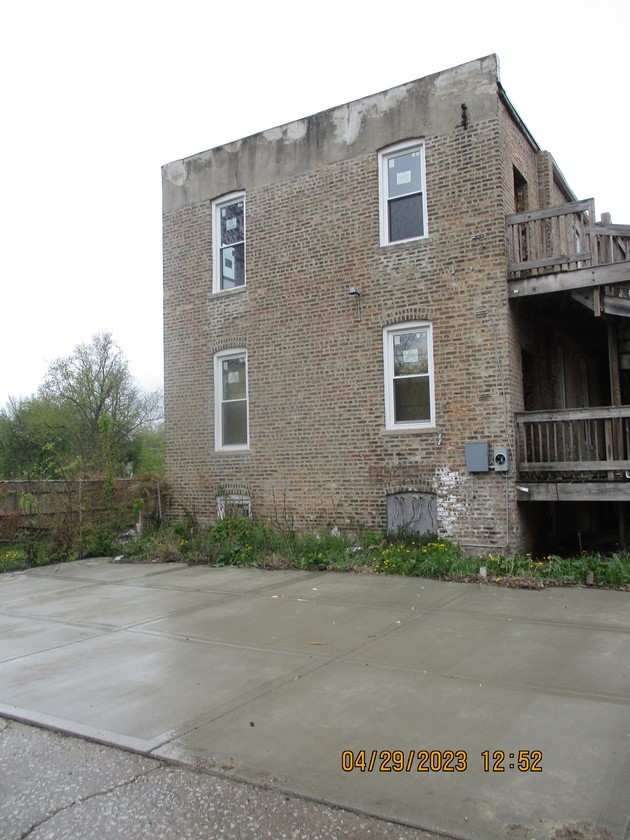5921 South Morgan Street Chicago, IL 60621 - Photo 4 of 9 a brick house with a small yard and a large parking space
